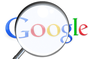 Bild på Googles logga och ett förstoringsglas